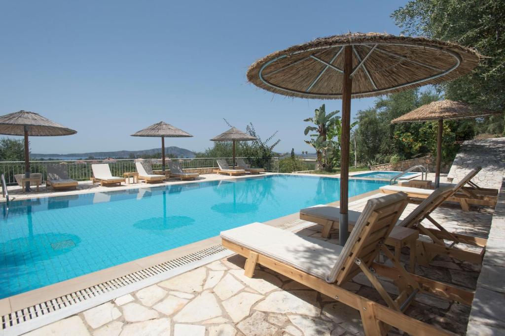 una piscina con sillas y sombrillas en Panorama Gialovas en Gialova