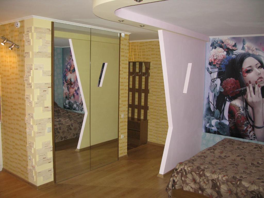 Zimmer mit einem Bett und einem großen Wandgemälde in der Unterkunft Уютная квартира ФЕНТЕЗИ in Krywyj Rih