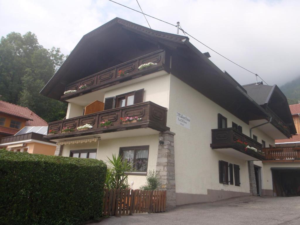 une grande maison blanche avec un toit noir dans l'établissement Müllnerhaus, à Millstatt