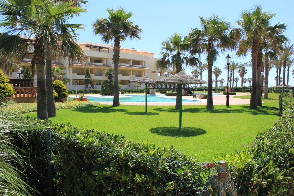 een resort met een park met palmbomen en een zwembad bij Villa Romana Roquetas in Roquetas de Mar