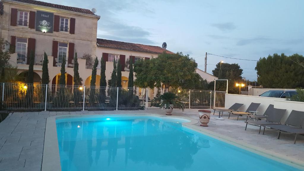 a swimming pool in front of a building at Hotel Le Mas Saint Joseph in Saint-Rémy-de-Provence