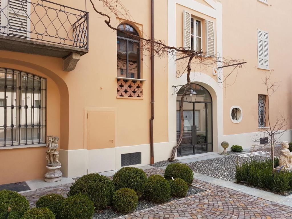 uma entrada para um edifício com uma porta e arbustos em Casa Sironi em Tortona