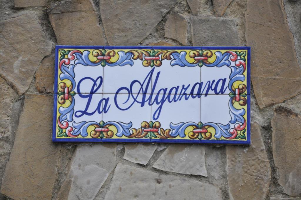 ein Schild an der Seite einer Steinmauer in der Unterkunft La Algazara in Villamartín