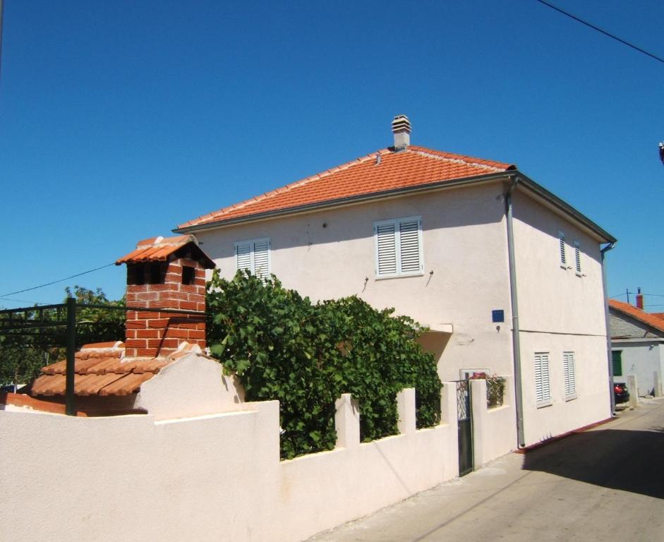 a white house with a white fence next to it at Apartmani Stipanelo in Murter