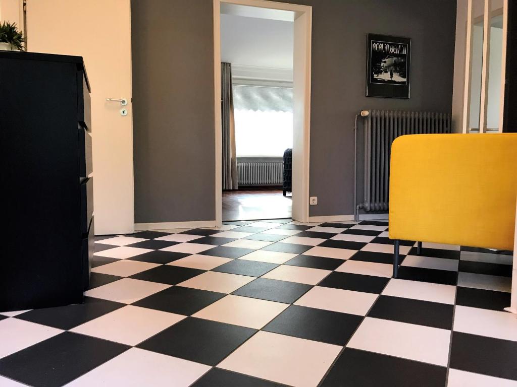 een kamer met een geruite vloer en een gele stoel bij The Kreideberger - Haus mit Platz in Lüneburg