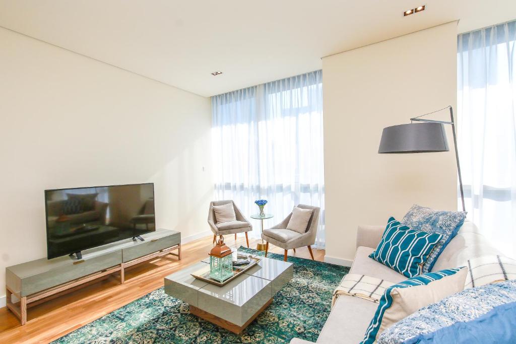 sala de estar con sofá y TV en Largest 2BR Family Suite w Maid's Room, City Walk en Dubái