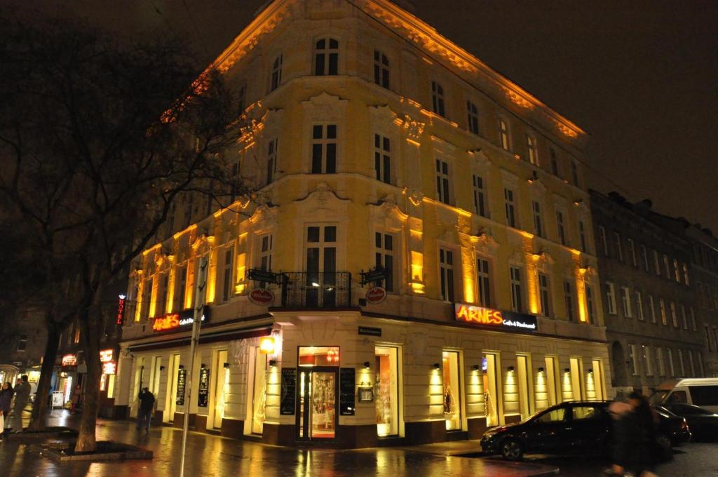 a large white building on a city street at night at Arnes Hotel Vienna in Vienna