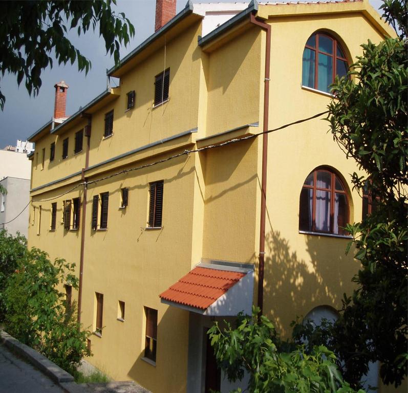 a yellow building with a red roof at Rooms Raulo in Split