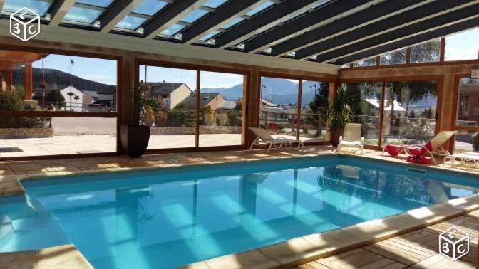 ein Schwimmbad mit Blick auf die Berge in der Unterkunft CHEZ LYLi & COMPAGNIE, PISCINE, JACCUZZI, SALLE DE SPORT in Bolquere