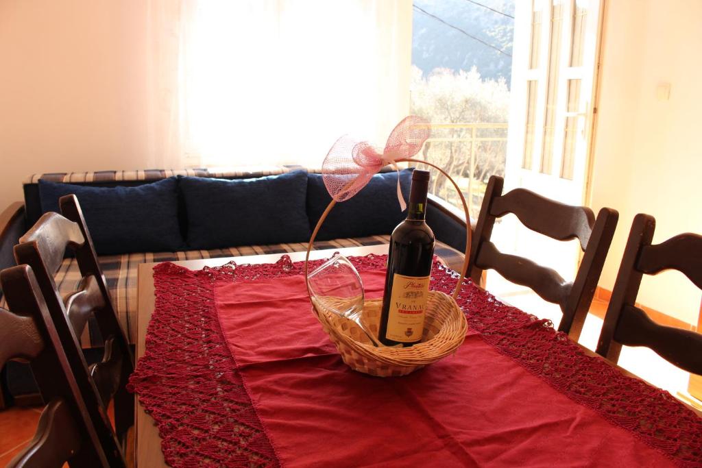 butelkę wina i kosz na stole w obiekcie Apartments Todorovic w Petrovacu na Moru