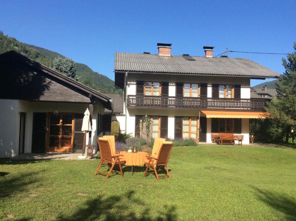 a house with a table and chairs in the yard at Ferienwohnungen Familie Wetzlinger in Bad Kleinkirchheim