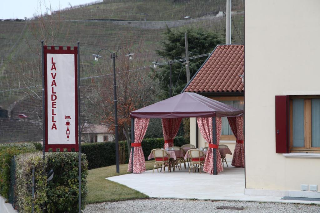 um grupo de mesas e cadeiras sob um gazebo em La Valdella em Valdobbiadene