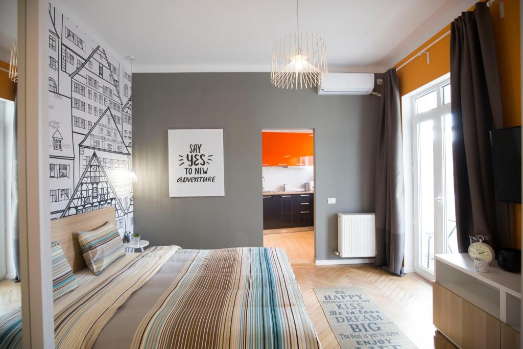 ein Schlafzimmer mit einem Bett und einer Wand mit Zeichnungen darauf in der Unterkunft Central Up Studio in Bukarest