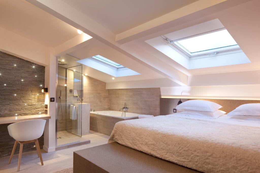 1 dormitorio con 1 cama grande y bañera en Georgette Hôtel & Restaurant en París