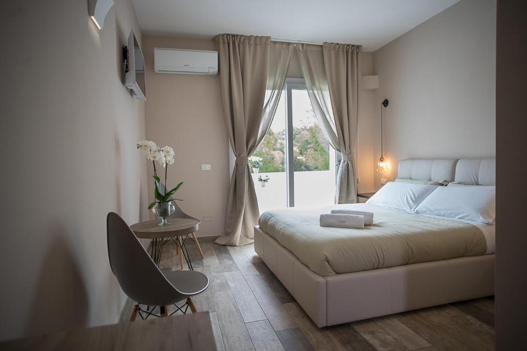 1 dormitorio con cama, mesa y ventana en B&B Sorahnia - Design House, en Agrigento
