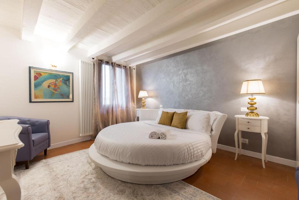 a bedroom with a white bed and a blue couch at Residenza Vescovado in Vicenza