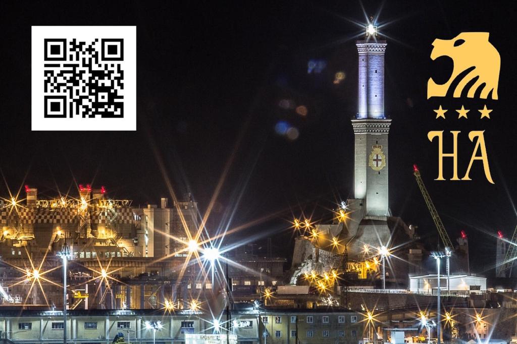 un grande edificio con torre dell'orologio di notte di New Alexander Hotel a Genova