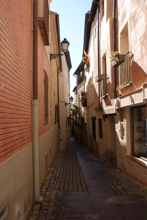 un callejón vacío con un edificio de ladrillo y una calle con un edificio en Toledo Histórico, en Toledo
