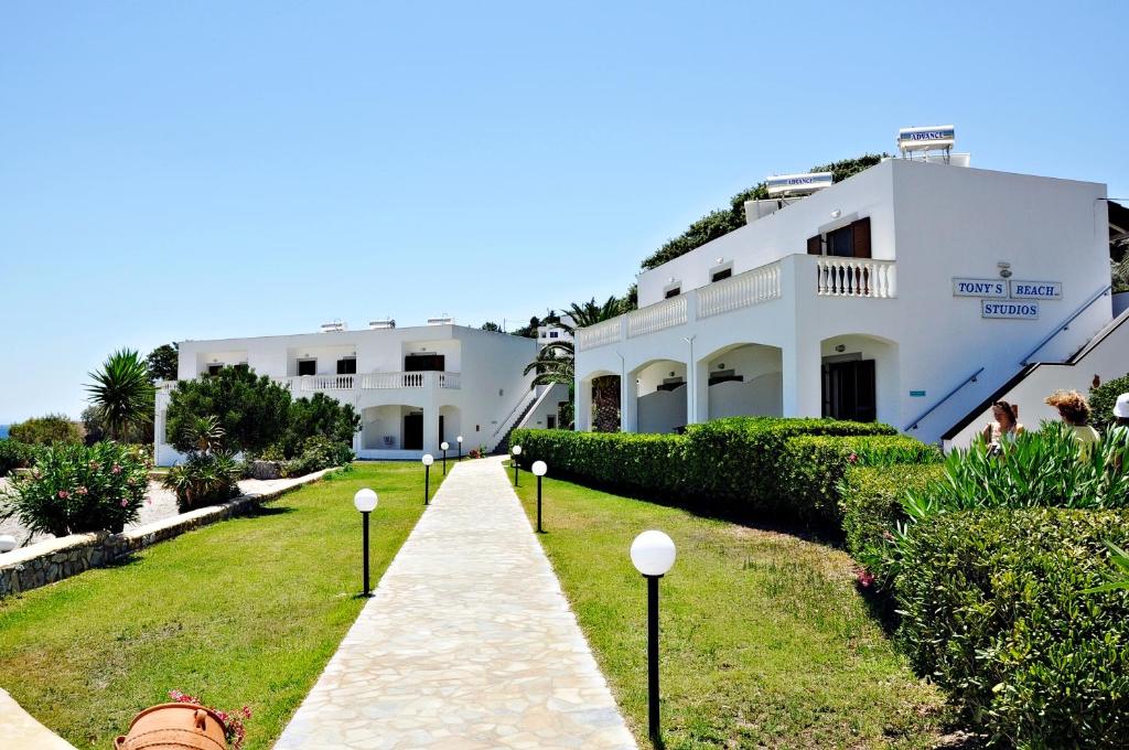 a walkway leading to a white building at Tony's Beach in Vromolithos