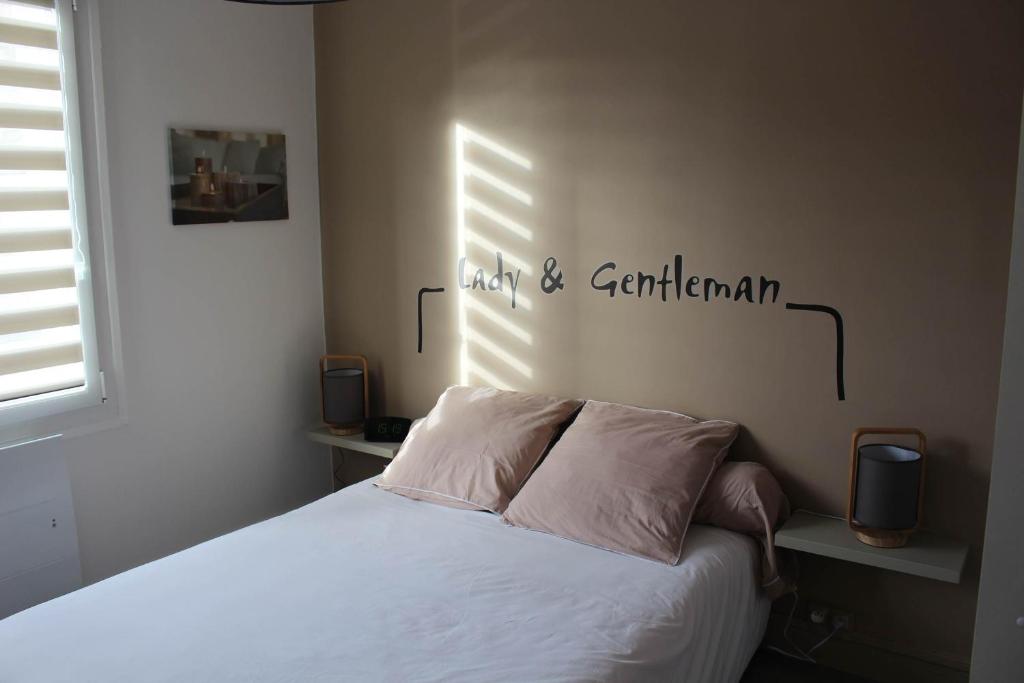 a bedroom with a bed and a sign on the wall at Appartement Quai Ouest in Dieppe