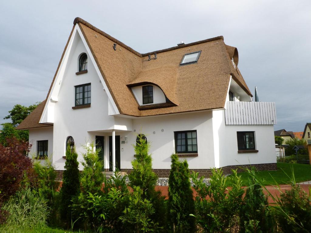 ein weißes Haus mit braunem Dach in der Unterkunft Zingst in Zingst