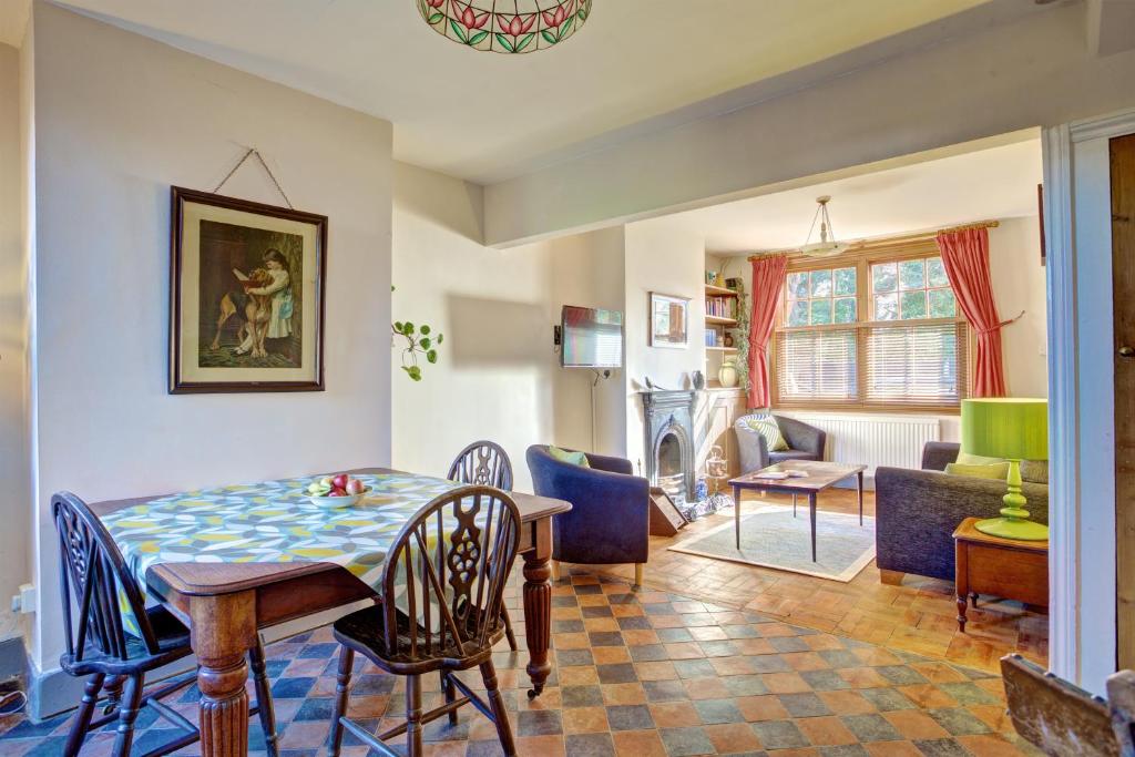 a dining room and living room with a table and chairs at St Johns House in Ely