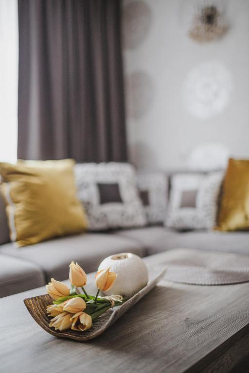 a plate of flowers on a table in a living room at Apartament Hubalczyków in Słupsk
