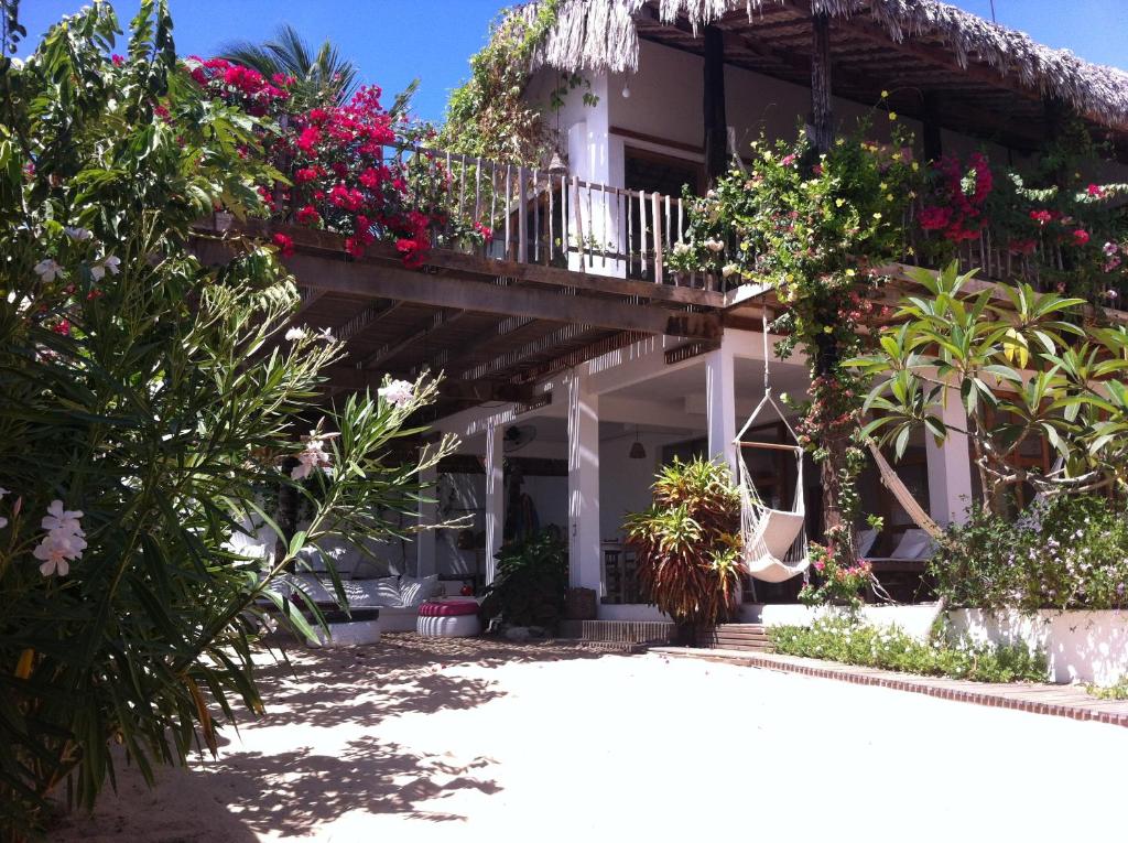 a house with a balcony with flowers and plants at Casa da Gwen in Jericoacoara