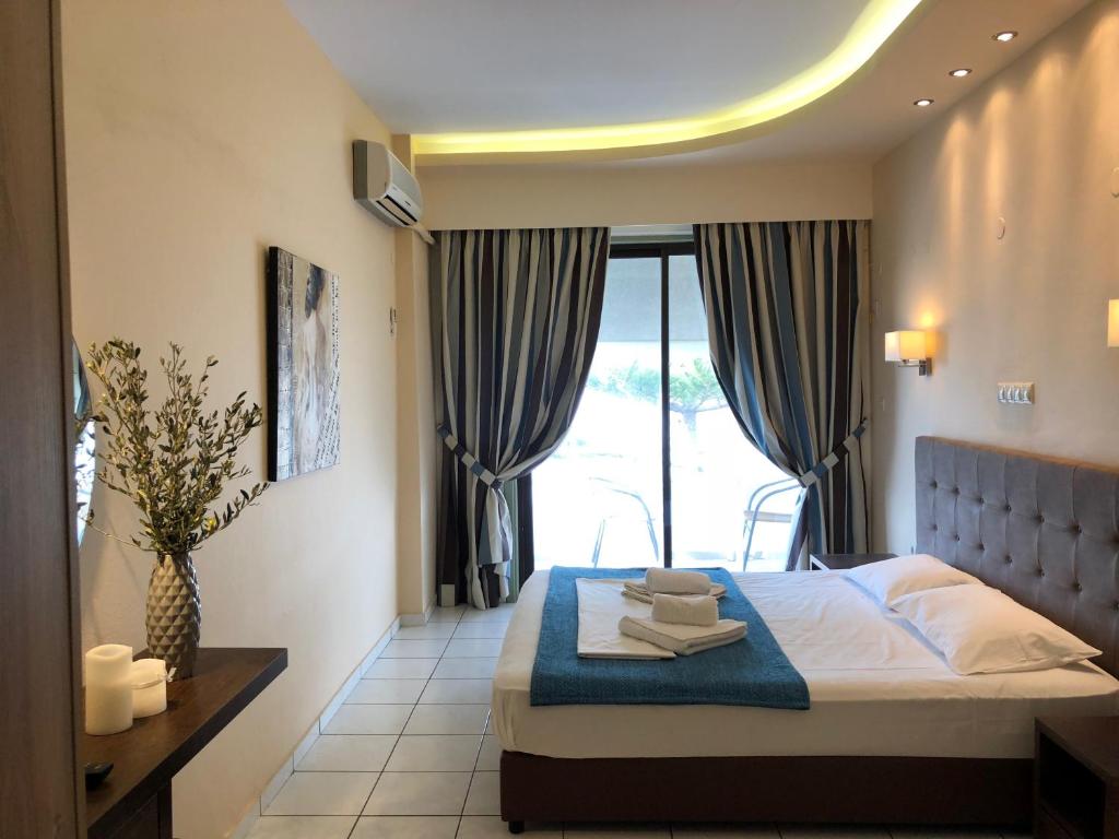 a bedroom with a bed and a large window at Oleander in Platanes
