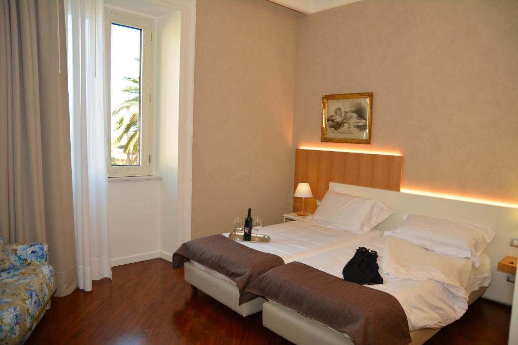 un dormitorio con una cama con un gato sentado en ella en B&B Villa Maria, en Giarre