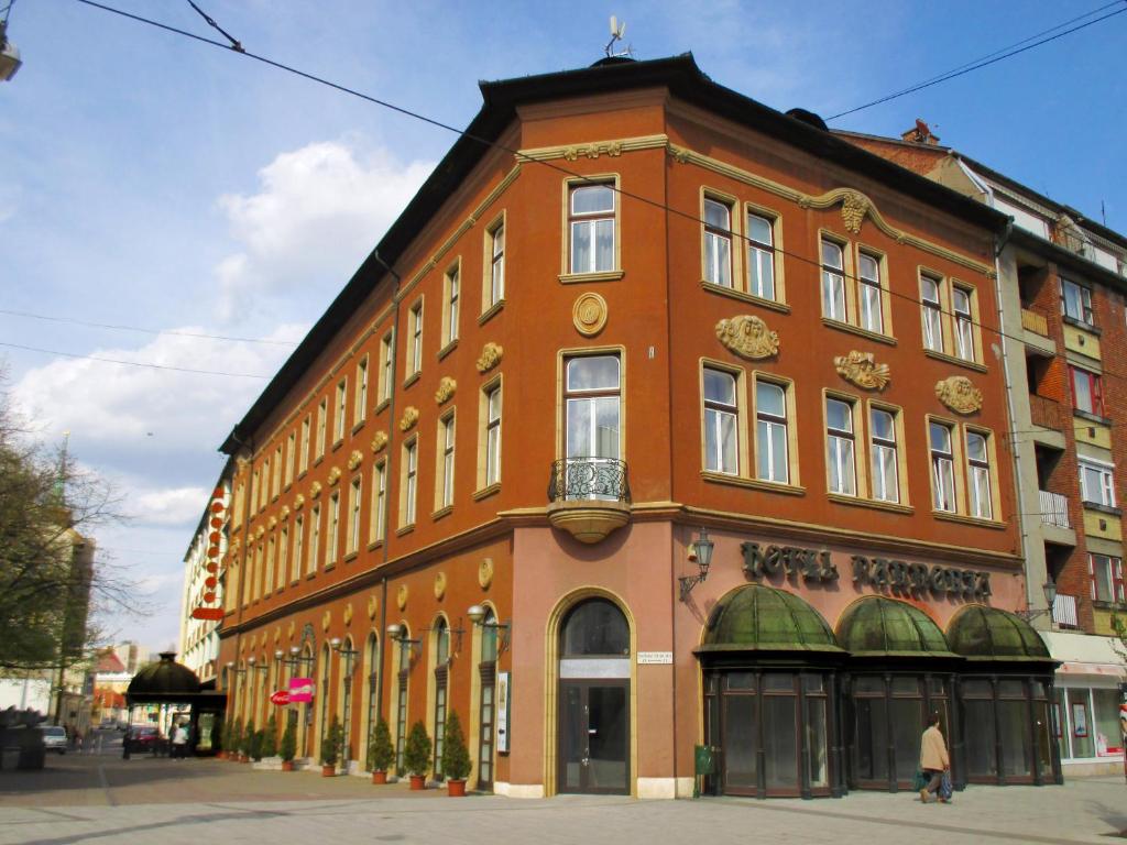 um grande edifício de tijolos na esquina de uma rua em Hotel Pannonia em Miskolc