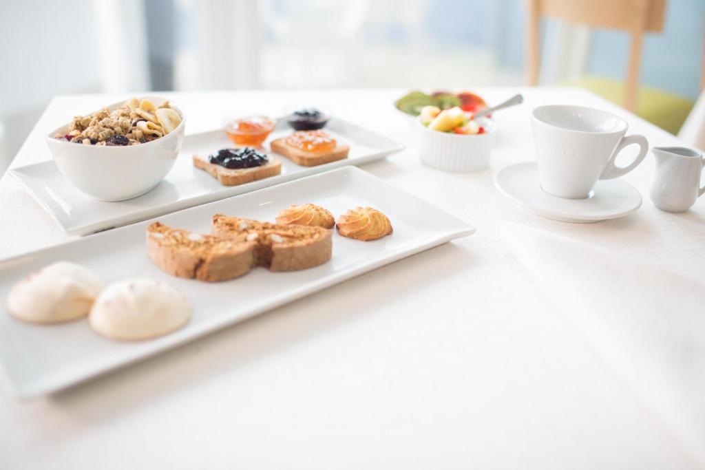 a table with two plates of pastries and cups of coffee at Hotel Mediterraneo in Sottomarina