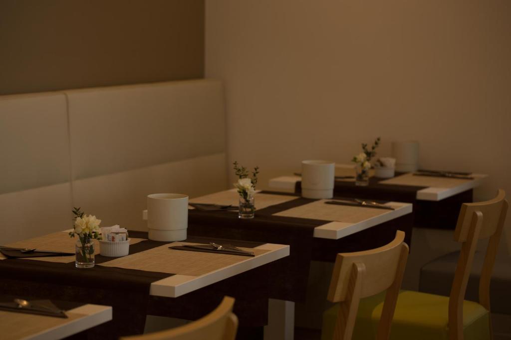 a room with three tables and chairs with flowers on them at Hotel Mediterraneo in Sottomarina