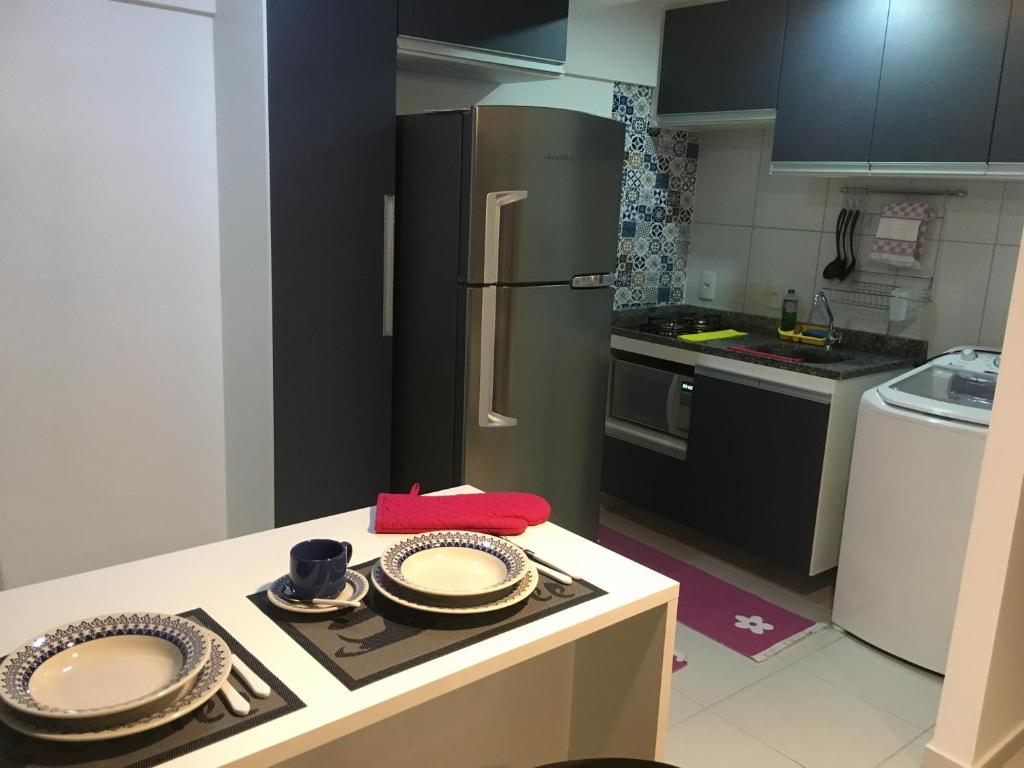 a kitchen with a refrigerator and plates on a table at Smart Residence Flat - 509 in Teresina