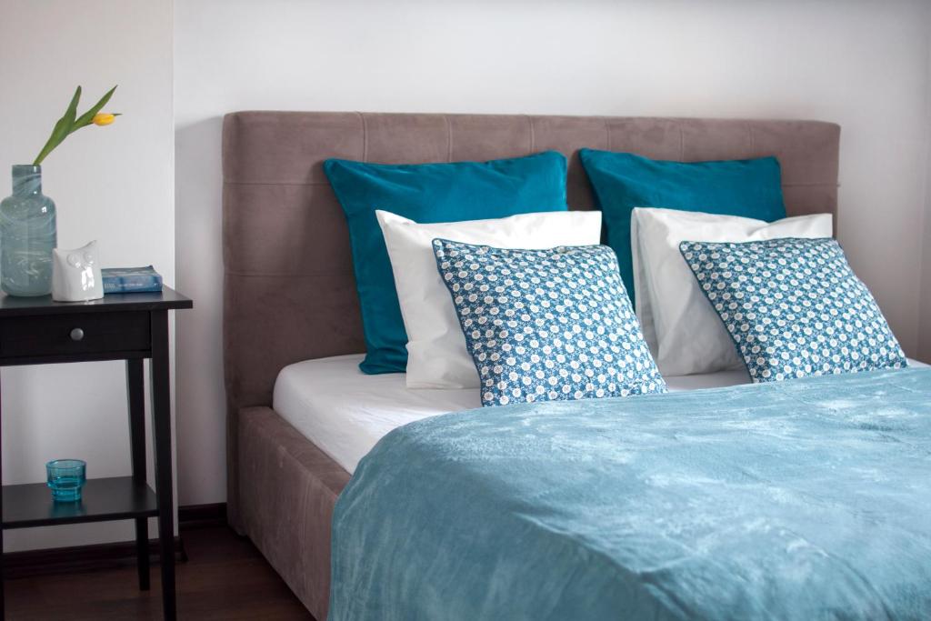 a bed with blue and white pillows on it at Apartament Myślenice in Myślenice