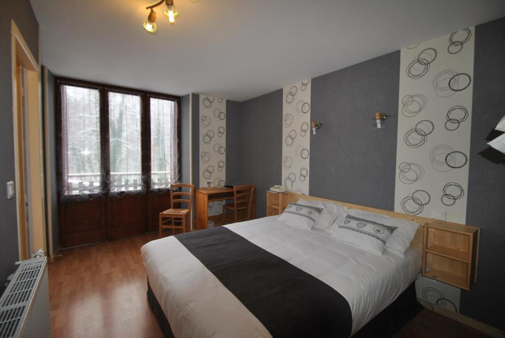 a bedroom with a large bed and a table and chairs at Auberge du Hérisson in La Chaux-du-Dombief