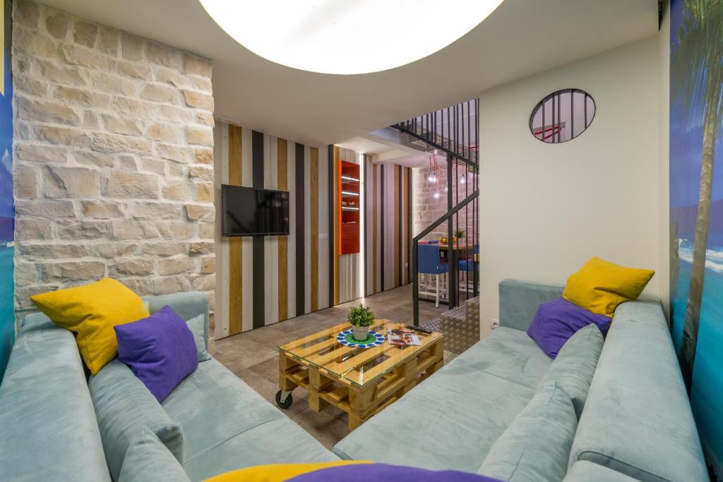 - un salon avec un canapé bleu et des oreillers jaunes dans l'établissement Petra design apartment, à Dubrovnik