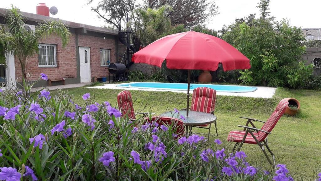 卡塔馬卡的住宿－La Chacarita apart，院子里设有两把椅子和一张桌子及一把遮阳伞