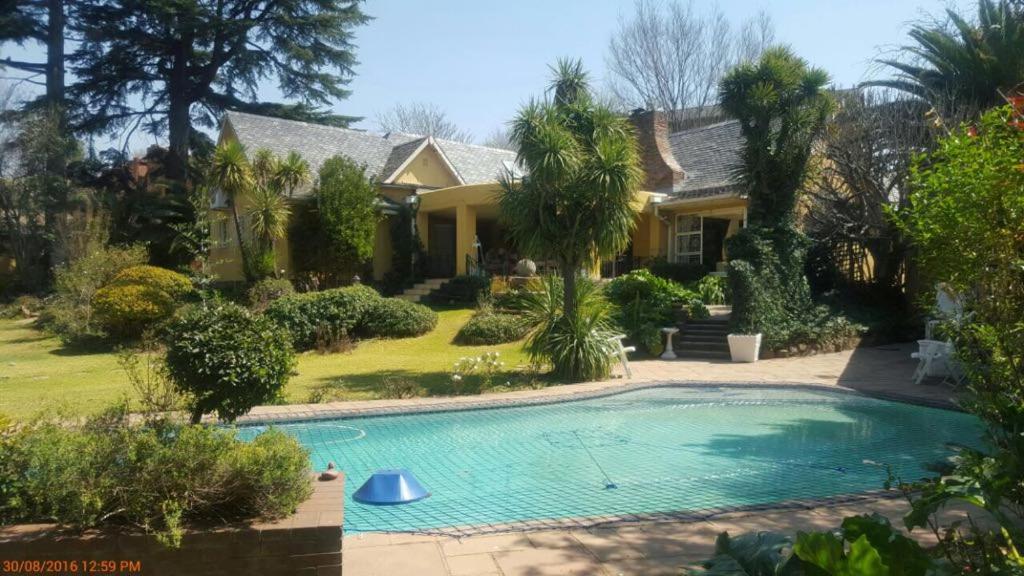 a house with a swimming pool in the yard at Villa MikaMora in Johannesburg