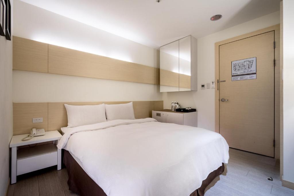 a bedroom with a large white bed in a room at Wemeet Hotel Taipei in Taipei