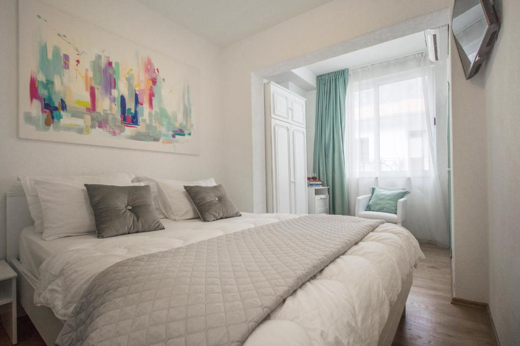 a bedroom with a large white bed with a window at Apartmani Leo-Marin in Makarska