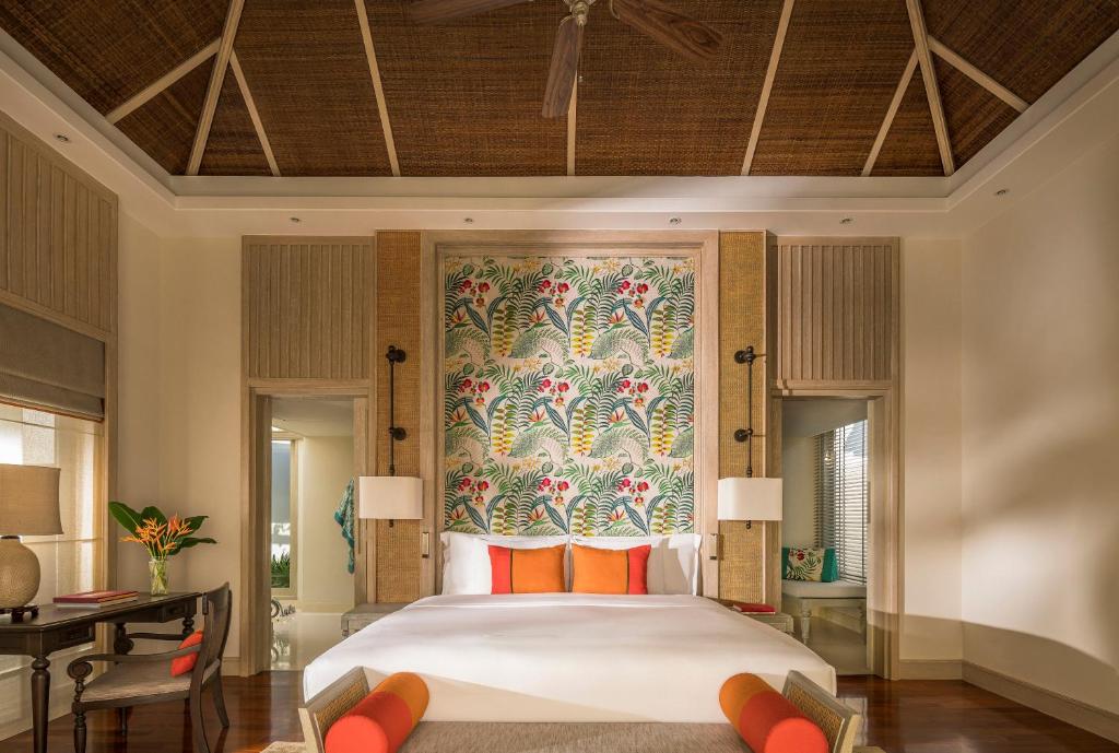ein Schlafzimmer mit einem großen Bett mit Wandbild in der Unterkunft Anantara Mai Khao Phuket Villas in Mai Khao Beach