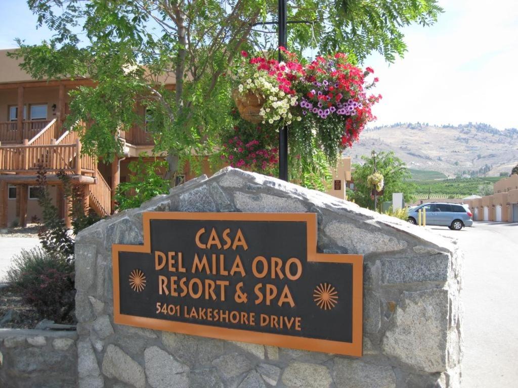 a sign for a restaurant and spa on a stone wall at Casa Del Mila Oro in Osoyoos