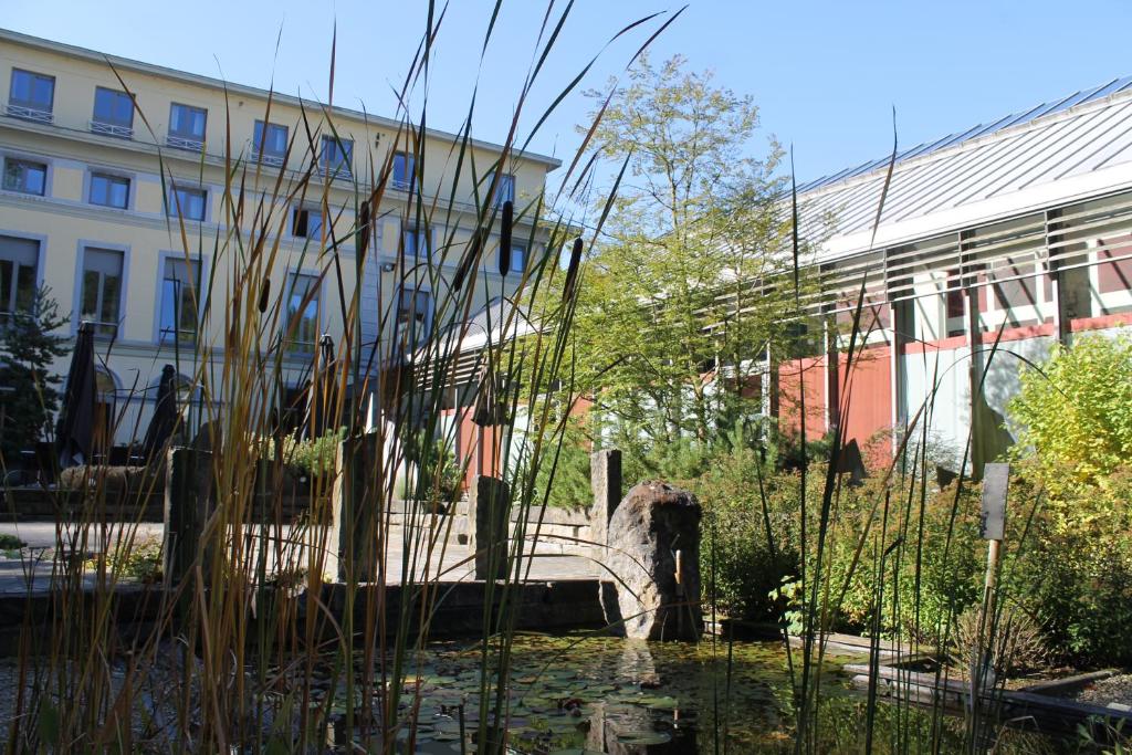 a building with a pond in front of a building at Castel de Pont-a-Lesse in Dinant