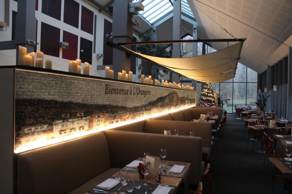 a dining room with tables and candles on the wall at Castel de Pont-a-Lesse in Dinant