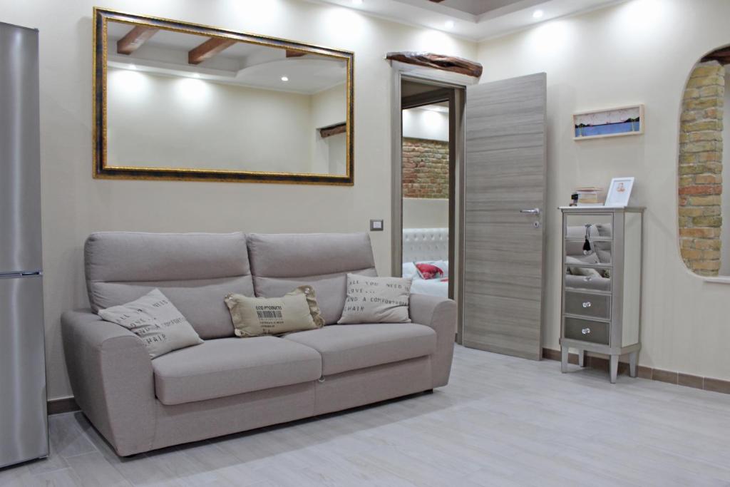 salon z kanapą i lustrem w obiekcie Flamingo Luxury Apartment AJPSARDINIA w Cagliari