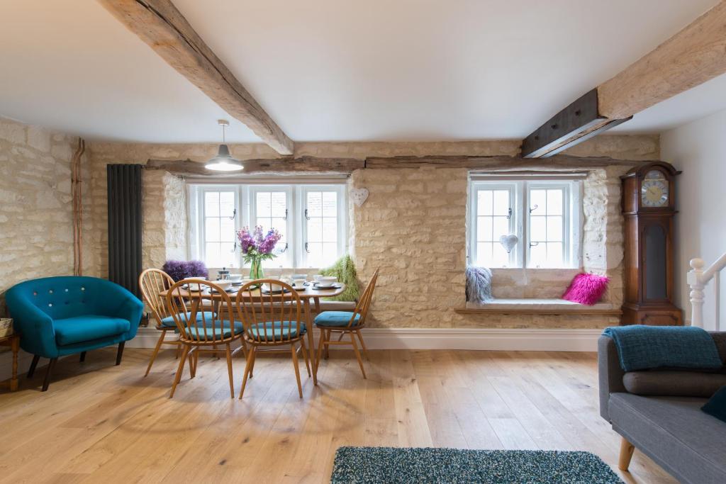 a living room with a dining room table and chairs at Upper Flat, The Manse, Painswick in Painswick