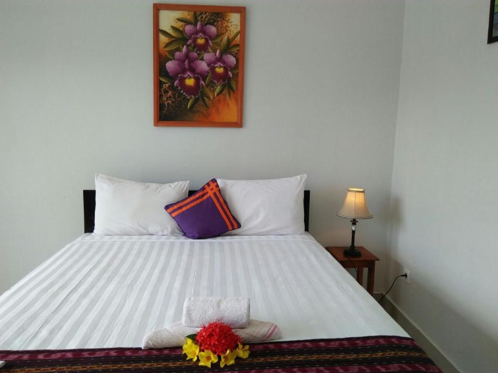 a bedroom with a white bed with a stuffed animal on it at CF Komodo Hotel in Labuan Bajo