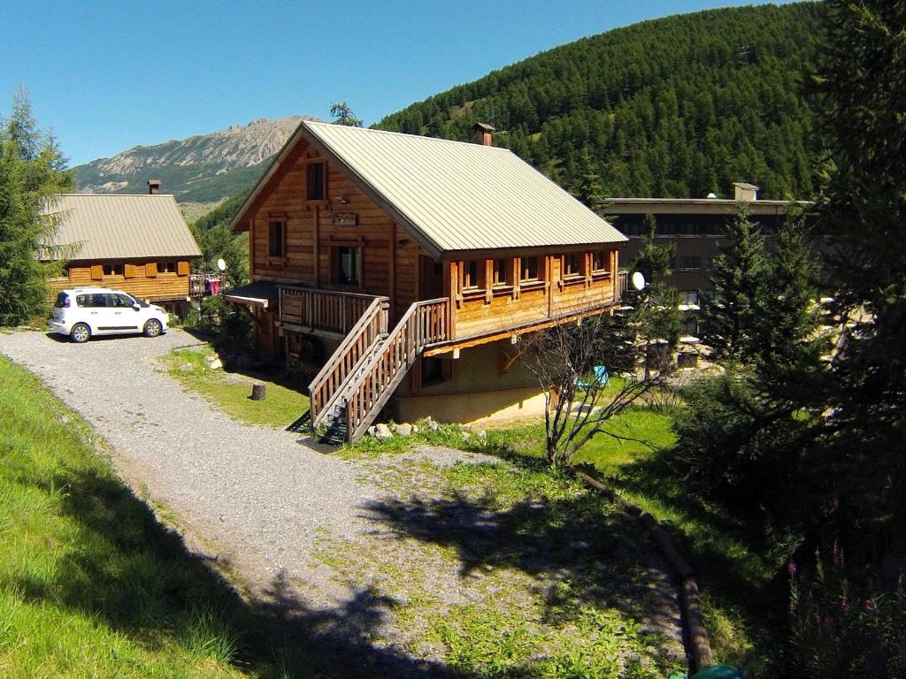 a log cabin with a car parked in front of it at Le Martagon in Vars