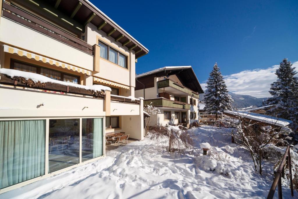 a building with snow on the ground next to it at Residence Ulrike in Nova Levante